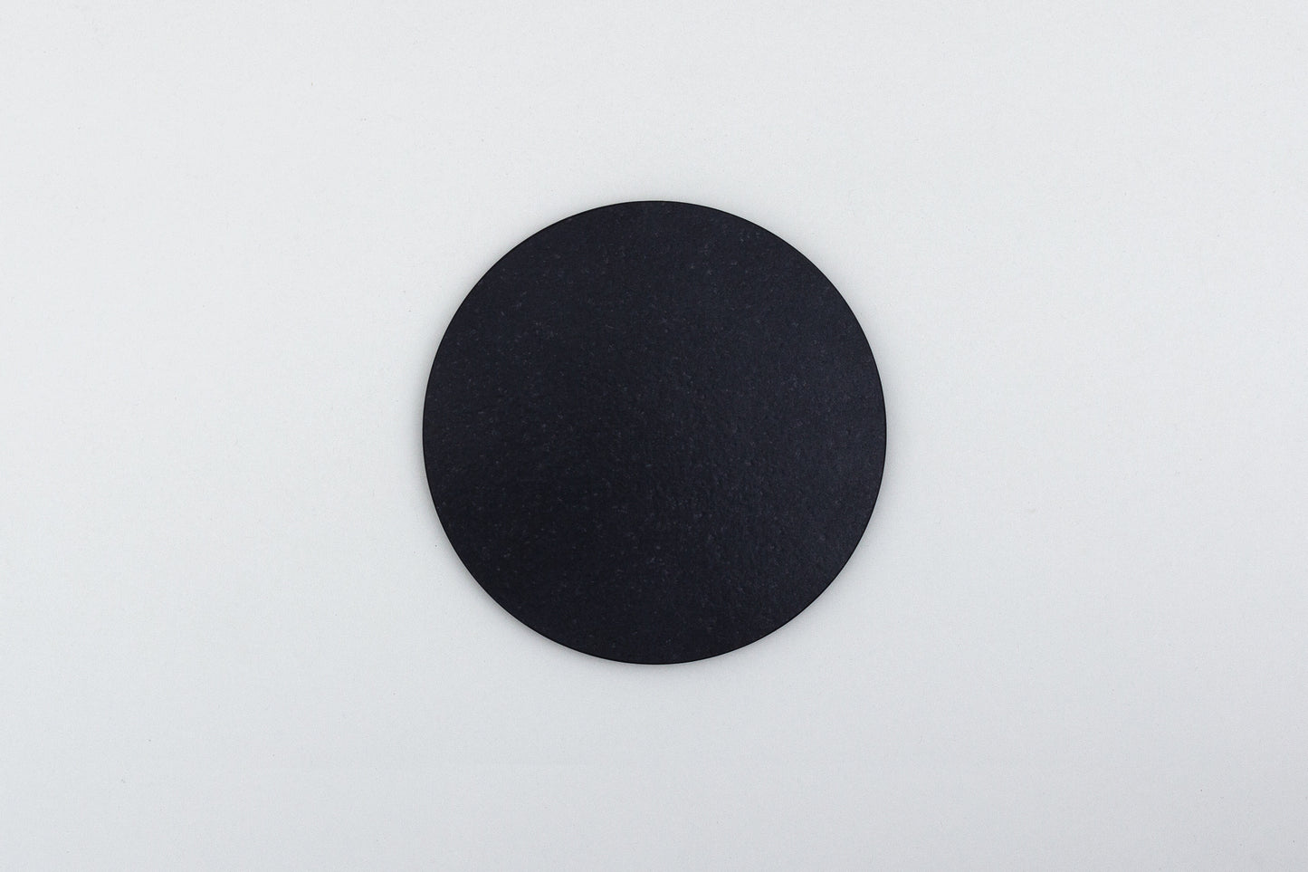 Légère - runde Dekoplatte aus Nero Assoluto mit Kork unterlegt